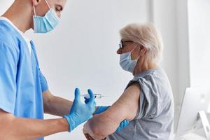 Alten Frau Nächster zu das Arzt Arm Injektion Impfstoff Reisepass Immunisierung Sicherheit foto