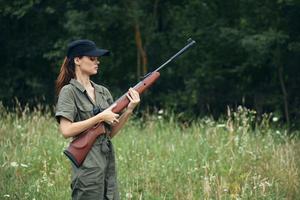 Frau Soldat mit ein Waffe im Hand, ein schwarz Deckel ist Neuladen Grün Overall foto