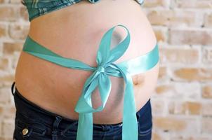 blaues Band am schwangeren Bauch foto