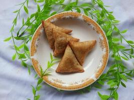 indonesisch Gemüse Sambusa mit Fleisch Fisch Füllung auf ein Mini Platte. ein Sambusa oder Samosa ist ein gebraten oder gebacken Gericht mit ein Bohnenkraut Füllung, eine solche wie Union, Fleisch Fisch, und Andere. nehmen Bild von oben foto