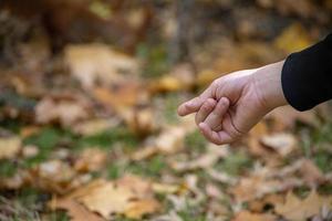 Kinder Hand zeigen etwas mit ein Finger auf ein braun verschwommen Hintergrund foto