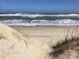 Wellen und Sand Dünen durch das Meer foto