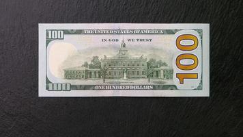 einer hundert Dollar Rechnung auf ein schwarz Teller zurück Aussicht finanziell Konzept foto