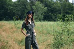 Frauen im Natur im das Wald im ein Blau Deckel hält Hände im Taschen foto