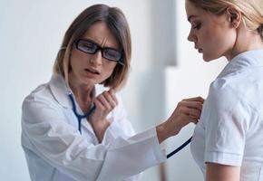 Arzt und geduldig auf Licht Blau Hintergrund Stethoskop Gesundheit Probleme abgeschnitten Aussicht foto