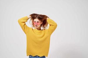 Frau im ein Gelb Sweatshirt Frisur Mode Brille posieren Studio foto