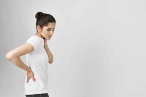 Frau im Weiß T-Shirt Gesundheit Probleme zurück Schmerzen foto