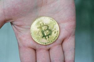 Mann hält Bitcoin in der Hand foto