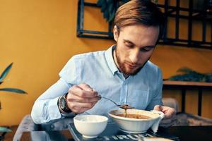 Geschäft Mann im Blau Hemd haben Mittagessen beim ein Cafe Tabelle foto