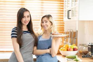 zwei kaukasisch Frauen Kochen Pizza zusammen im das Küche. das Konzept von Zuhause gekocht Essen und lgbt Beziehungen. Familie und Vielfalt Konzept. lgbt Liebe. foto