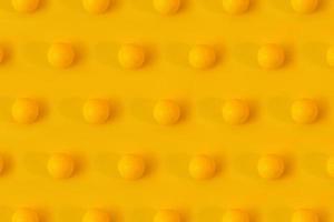 gelbe Golfbälle auf gelbem Hintergrund kreatives Konzept. monochromes Farbschema. sich wiederholendes Texturmuster. foto
