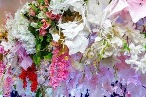 bunt künstlich Papier Blumen hängend auf ein Bühne. Hochzeit Dekoration. Plastik bunt dekoriert Blume. foto