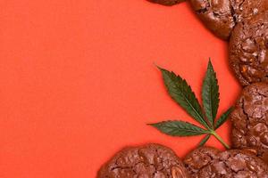 Kekse mit Cannabis auf einem orangefarbenen Hintergrund foto