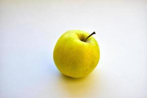 gelbgrüner Apfel auf einem weißen Hintergrund schließen oben