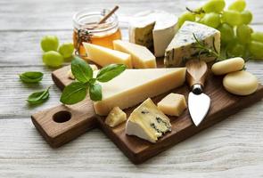 verschiedene Arten von Käse auf einem weißen hölzernen Hintergrund foto