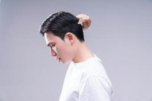 Bild von jung asiatisch Mann Haar Pflege auf Hintergrund foto