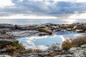 Wolken reflektieren im ein Schwimmbad von Wasser auf das robust Ufer von See überlegen beim Pukaskwa National Park, Marathon, Ontario foto