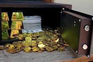 Goldmünzen, die aus dem Safe verschüttet werden foto