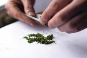 Verdrehen des Pfostens mit medizinischem Marihuana, Nahaufnahme der Cannabisbehandlung foto