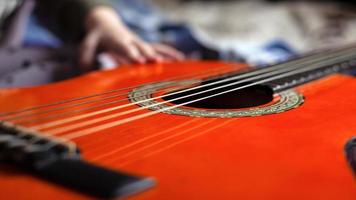 Kind lernt ein Musikinstrument zu spielen, die Akustikgitarre foto