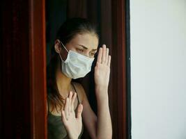 Frau venezianisch Maske halt Hände auf Fenster traurig Ausdruck Sperrung foto