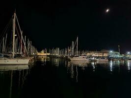 Nacht Landschaft von das Hafen mit Yachten im alicante Spanien mit das Mond foto
