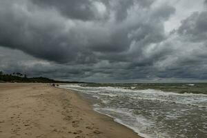breit Strand auf das baltisch Meer im Polen auf ein Sommer- wolkig grau kalt Tag foto