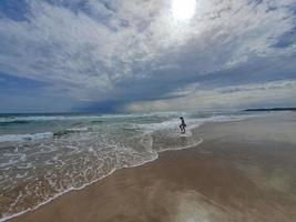 heiter Strand Landschaft mit Himmel mit Wolken und Wellen foto