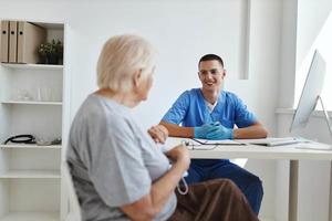 ein Alten Frau reden zu ein Arzt ein Besuch zu das Krankenhaus foto