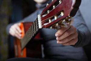 Mädchen stimmt eine Akustikgitarren-Nahaufnahme foto