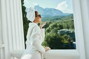 Porträt von Herrlich Frau im ein Weiß Kleid auf das Balkon bisschen auf Grün Natur Lebensstil foto