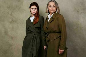 jung und alt Frauen Stand Seite durch Seite Herbst Mode Studio isoliert Hintergrund foto