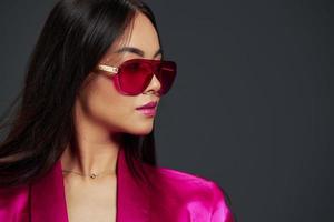 Frau im ein Rosa Mini Kleid Mode Brille Luxus grau Hintergrund foto