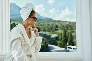 attraktiv jung Frau posieren gegen das Hintergrund von Berge auf das Balkon die Architektur unverändert foto