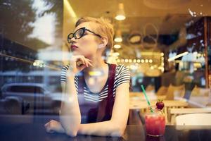 Frau mit Brille Sitzung allein im ein Cafe Cocktail Freizeit Lebensstil foto