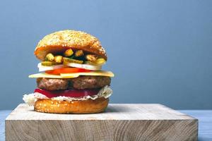 großer saftiger Burger mit Kopienraum auf grauem Hintergrund foto