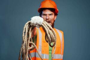 ein Mann im ein Arbeiten Uniform mit ein Seil im seine Hände Emotionen Konstruktion Lebensstil foto