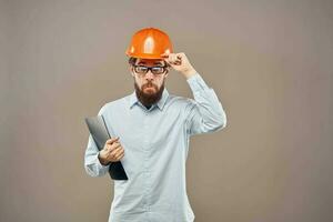 emotional Mann tragen Orange schwer Hut auf Industrie Unterlagen foto