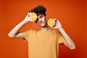 Kerl mit lockig Haar und halten ein Orange isoliert Hintergrund foto