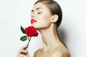 Brünette mit ein Rose Augen geschlossen nackt Schultern Modell- rot Lippen foto