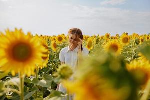 Frau mit Zöpfe im ein Feld von Sonnenblumen Landschaft foto