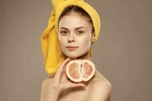 schön Frau mit ein Handtuch auf ihr Kopf entblößt Schultern Grapefruit Haut Pflege foto