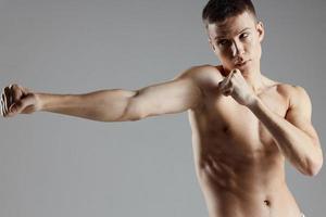Boxer mit ein nackt Torso Ausbildung auf ein grau Hintergrund Abs Würfel auf das Bauch foto