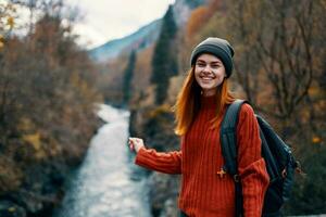 heiter Frau Wanderer auf das Brücke in der Nähe von das Fluss Berge Reise Natur foto