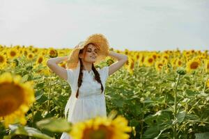 schön Süss Mädchen im ein Weiß Kleid Gehen auf ein Feld von Sonnenblumen unverändert foto