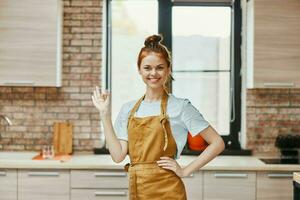 Frau im ein braun Schürze Gesten mit seine Hände Küche Innere unverändert foto