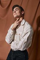 ein Mann im ein Weiß Hemd passt sich an seine Selbstvertrauen Studio Halsband foto