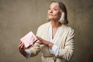 heiter Alten Frau mit Geschenk Tasche Urlaub Studio foto