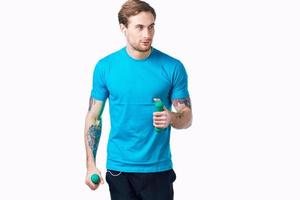 Mann im Blau T-Shirt mit Hanteln im Hand tätowieren Fitness trainieren foto
