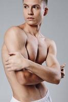 Athlet mit gepumpt Muskeln Drücken Sie Bodybuilder grau Hintergrund foto